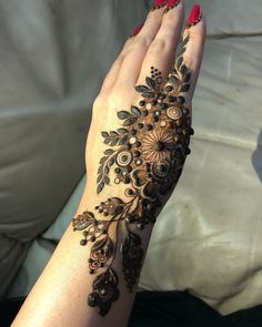 a woman's hand is decorated with hennap and flowers on her arm