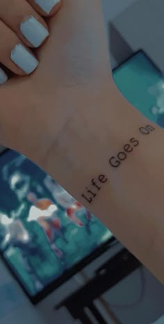 a woman's arm with the words life goes on it