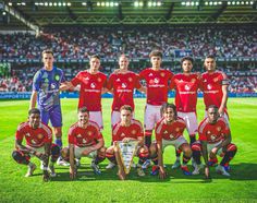 the soccer team is posing for a group photo on the field in front of an audience