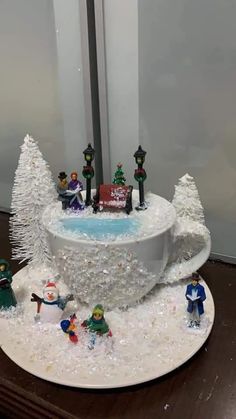 a christmas cake is decorated with snow and figurines