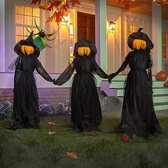 three witches holding hands in front of a house