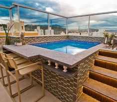 an outdoor hot tub with stairs leading up to it and a table next to it