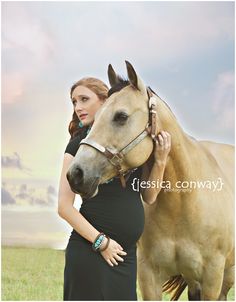 a pregnant woman standing next to a horse