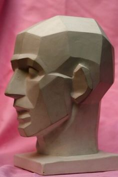 a paper sculpture of a man's head on a pink background