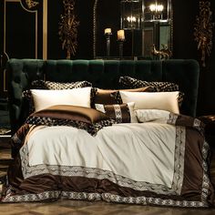 a bed with pillows and blankets on it in front of a green headboard filled with candles