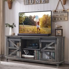 a flat screen tv sitting on top of a wooden cabinet