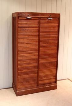 a tall wooden cabinet sitting in the corner of a room