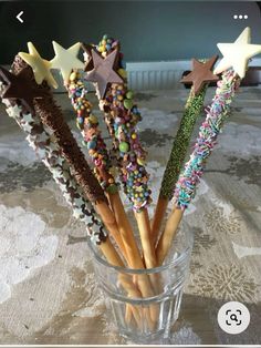 there are many stars and sprinkles on the sticks in this glass vase