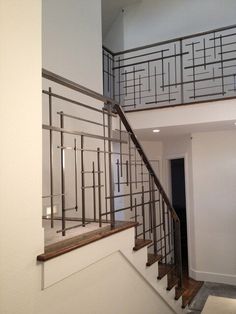 an open staircase leading up to the second floor with metal railings and wood handrails