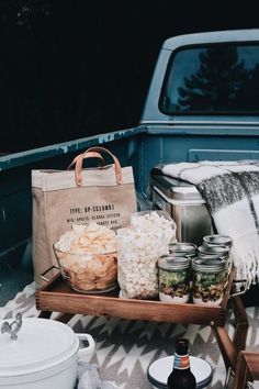 a picnic table with food and drinks in the back of a pick - up truck