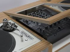 a record player and turntable sitting on top of a wooden table next to each other