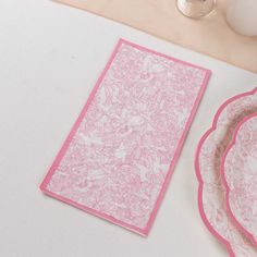 pink paper plates and napkins on a white table