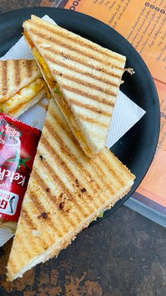 a plate with two sandwiches and a bag of chips next to it on a table