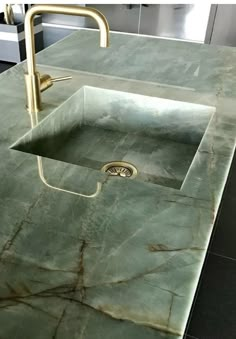 a green marble counter top with a sink and faucet in the middle is shown