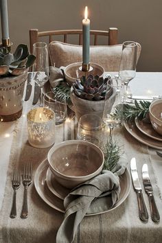 a table set for christmas with candles and plates