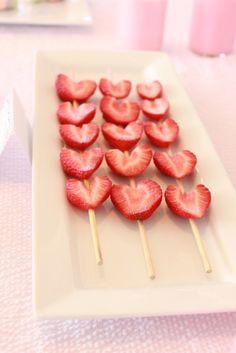 strawberries arranged on skewers in the shape of hearts are ready to be eaten