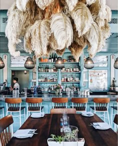 an image of a dining room setting with feathers hanging from the ceiling