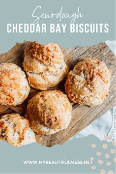 four cheddar bay biscuits on a wooden board with text overlay that reads sourdough cheddar bay biscuits