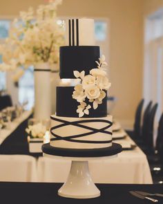 a black and white wedding cake with flowers on top