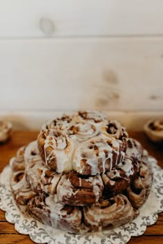 a plate topped with cinnamon rolls covered in icing on top of a wooden table