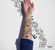 a woman's arm with a tattoo on it and leaves coming out of the wrist