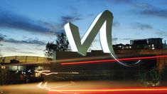 the letters v are lit up in front of a building at night with long exposure