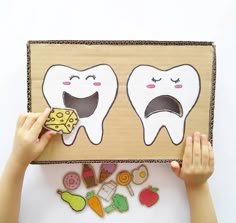 two children holding up a cardboard box with tooth and cheese cut out of it to look like they are smiling