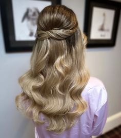 a woman with long blonde hair in a half - up hairstyle, wearing a pink dress