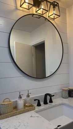 a bathroom sink under a round mirror