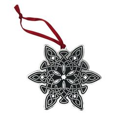 a black and white ornament hanging from a red ribbon on a white background