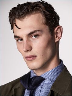 a young man wearing a suit and tie looking at the camera with a serious look on his face