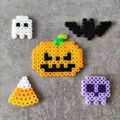 four perler bead pumpkins on the floor