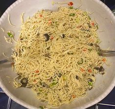 a pan filled with noodles and vegetables on the stove