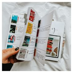 a person is holding an open book with pictures on it and writing in the pages