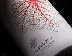 a close up of a bottle of wine on a black background with red and white designs