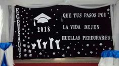 a black and white graduation banner hanging from the side of a wall with blue ribbon