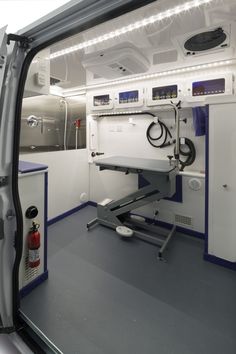 the inside of an ambulance with medical equipment in it's back door and lights on