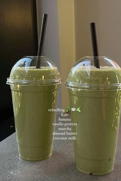 two plastic cups with straws in them sitting on a table