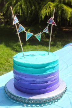 there is a cake with blue frosting and purple icing on the top tier