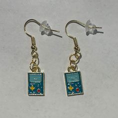 Adventure Time themed earrings: BMO! Set on a Nickel FREE, gold iron earrings or 18K Gold Plated, hypoallergenic hooks.  includes 2 free surprise stickers ! Bmo Adventure Time, Black Cat Earrings, Tiny Shop, Tacoma Wa, Cat Earrings, Adventure Time, Gold Accents, Friends In Love, Jewelry Earrings Dangle