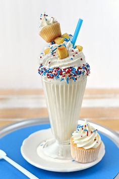 two cupcakes are sitting on a plate with white frosting and sprinkles