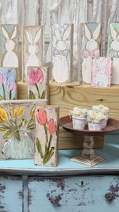 an assortment of easter cards and cupcakes sitting on a table next to a blue dresser