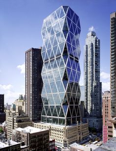 a very tall glass building in the middle of some big cityscape with skyscrapers behind it