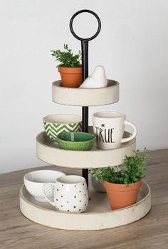 three tiered tray with cups and plants on it