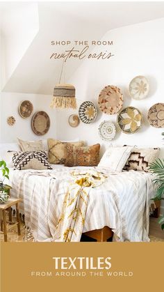 a bed sitting in a bedroom next to a wall with plates on it and the words textiles from around the world