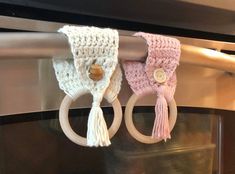 two crocheted rings hanging from the side of a microwave oven door with handles