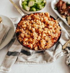 a bowl filled with macaroni and cheese on top of a white table cloth