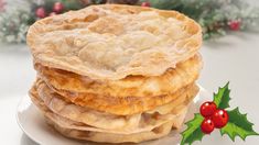 a stack of food sitting on top of a white plate next to a holly wreath