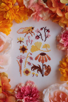 A finished cross stitch of a small, yellow, orange, and brown sampler. It features an adult yellow cicada, a cicada shell on an orange black-eyed susan flower, pink strawberries, various pink and yellow flowers, and yellow ginkgo leaves. Orange Cross Stitch, Cottagecore Cross Stitch Pattern, Yarn Hobbies, Golden Hour Nature, Summer Cross Stitch, Flowers Cross Stitch, String Crafts, Ginkgo Leaves, Cross Stitch Collection