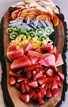 sliced fruit arranged on top of a wooden platter